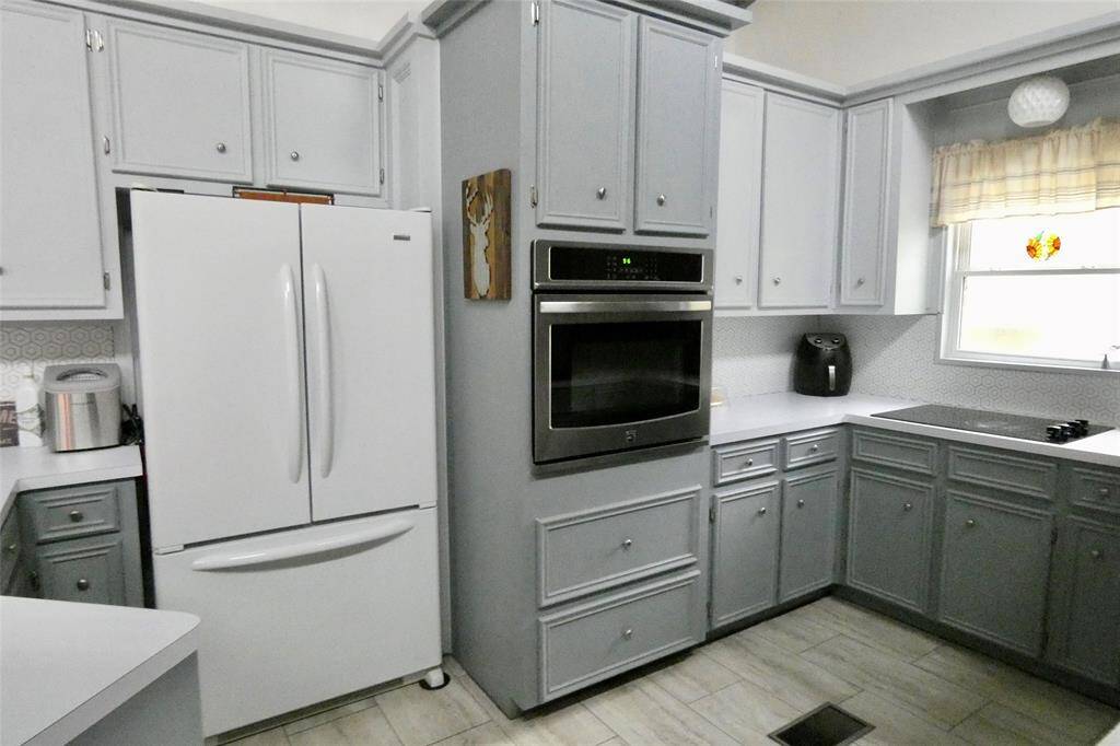 Breakfast bar with decorative tile, vaulted ceiling and windows