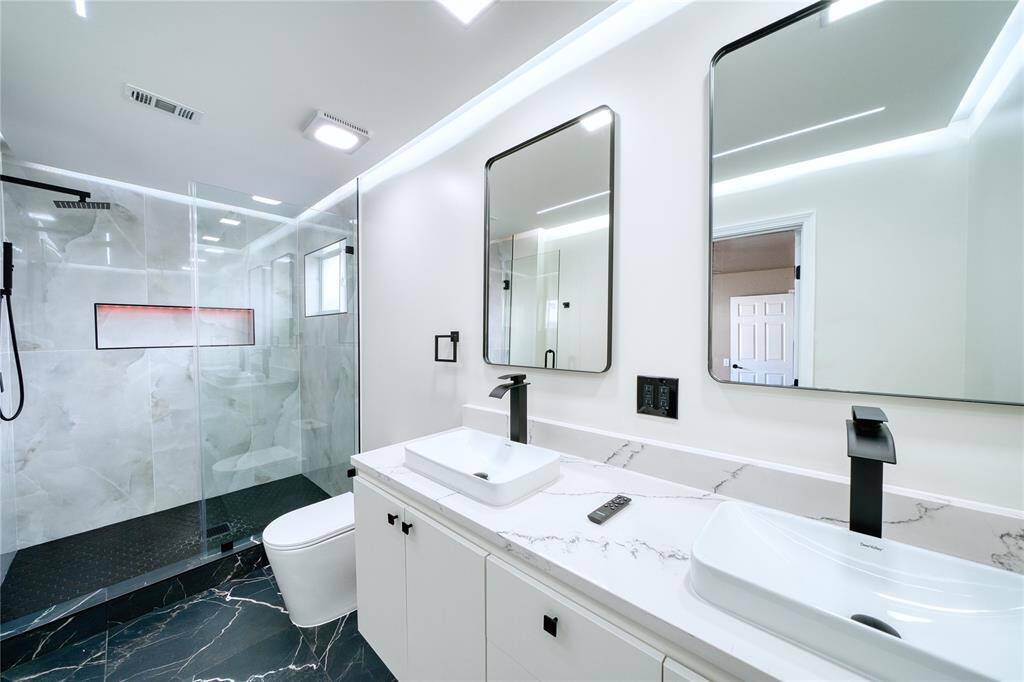 Newly renovated primary bathroom offers just the right touch of modern elegance and comfort.
