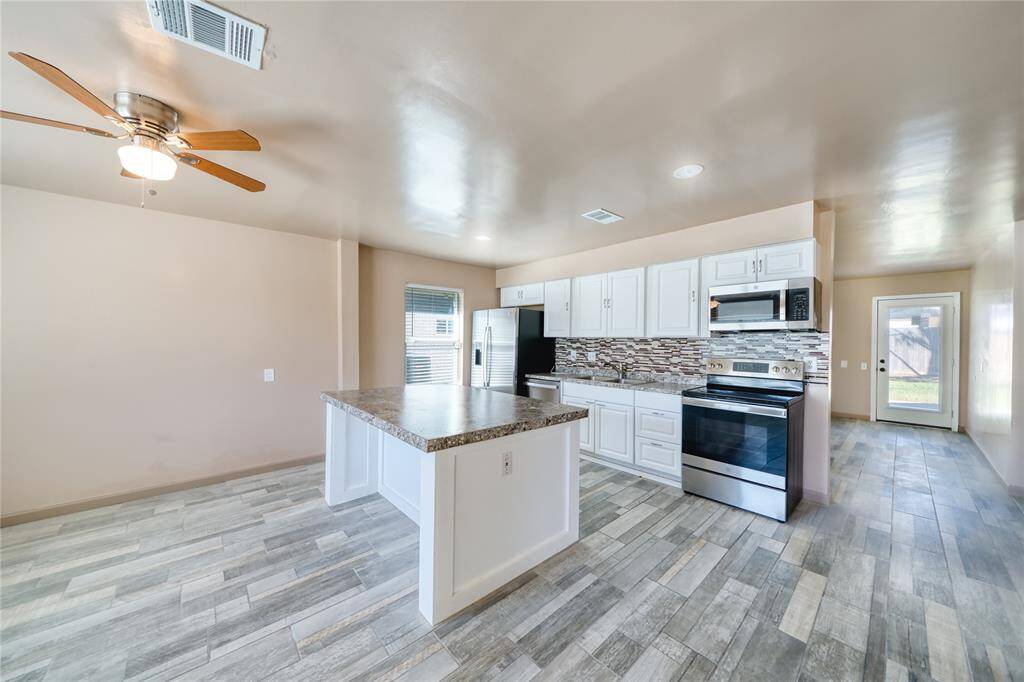 Updated kitchen and dining area features stainless steel appliances.
