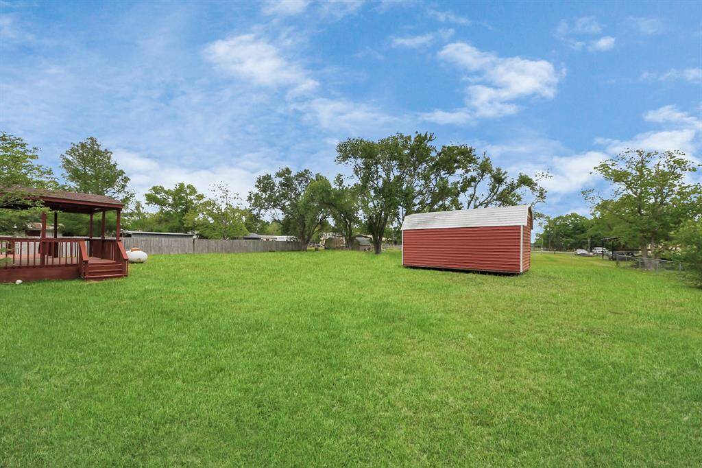 Completely fenced back yard with large storage shed.