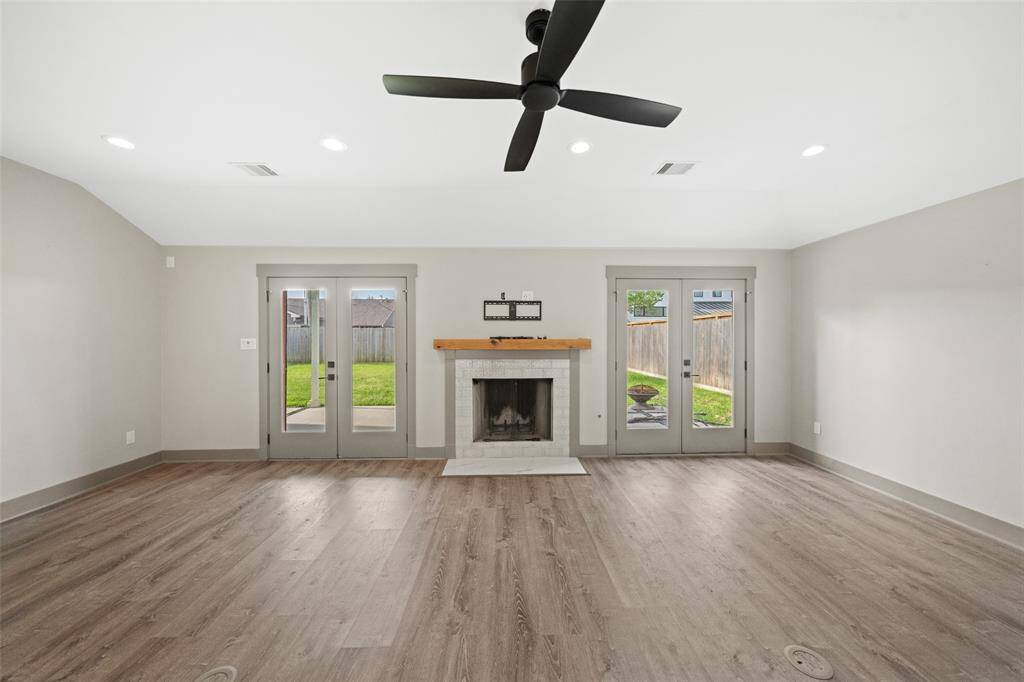 Looking out to the backyard, this bright family room centers around a cozy gas fireplace, creating a warm and inviting focal point.