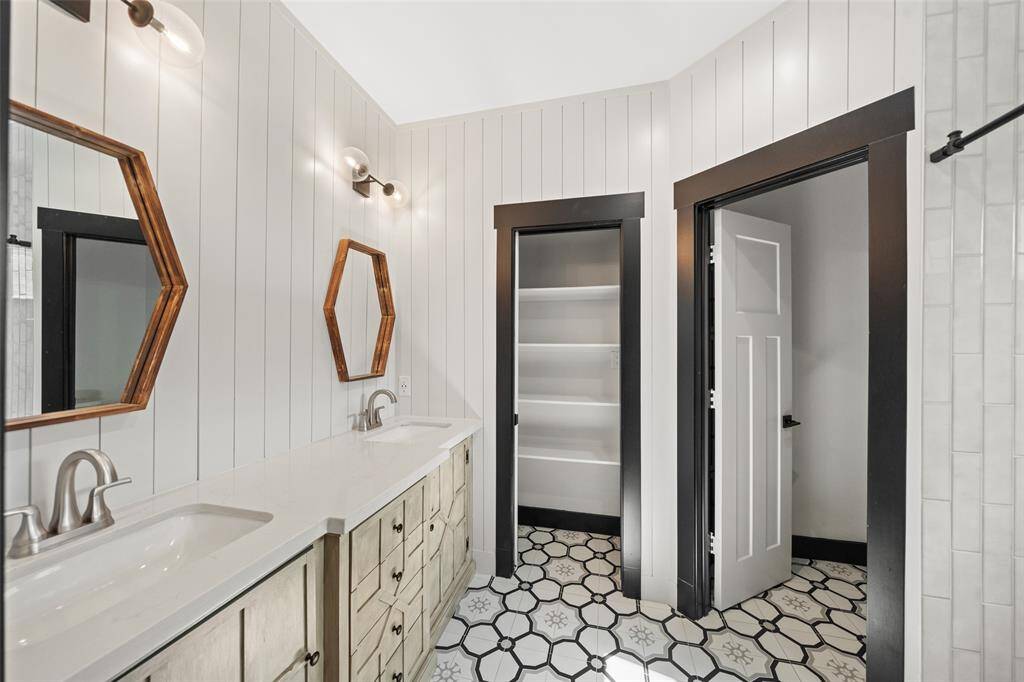 A custom vanity, shiplap walls, and ornate tile work make this primary bath feel both stylish and serene.