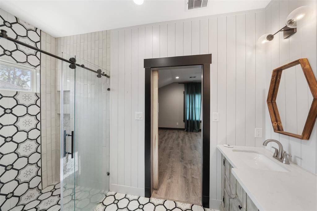 A frameless glass walk-in shower complete this primary retreat.