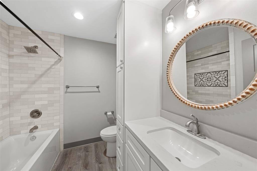 The secondary bath features a sleek vanity, linen storage and tub/shower combo.