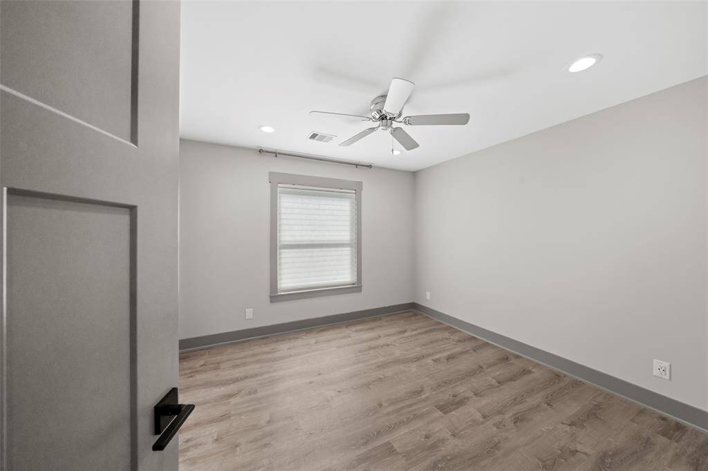 The second of the two additional bedrooms features matching laminate flooring and window coverings for added privacy.