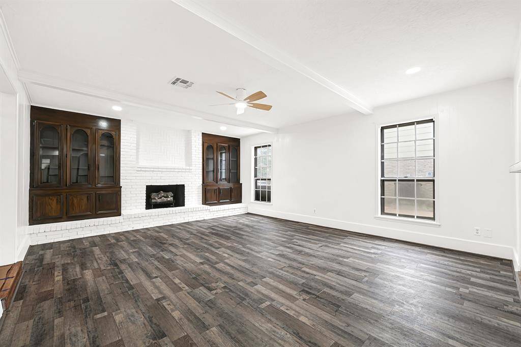 The living room features a fireplace, built in cabinetry and tons of natural light.