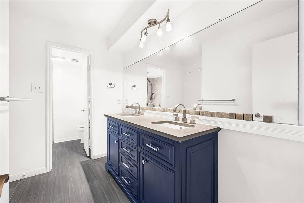 Secondary bathroom provides dual vanity sinks and a tub/shower combo.