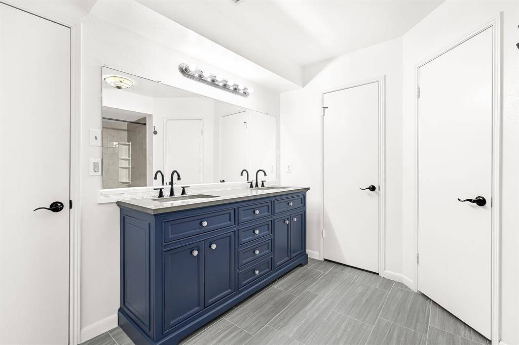 En-sute bath featuring dual vanity sinks.