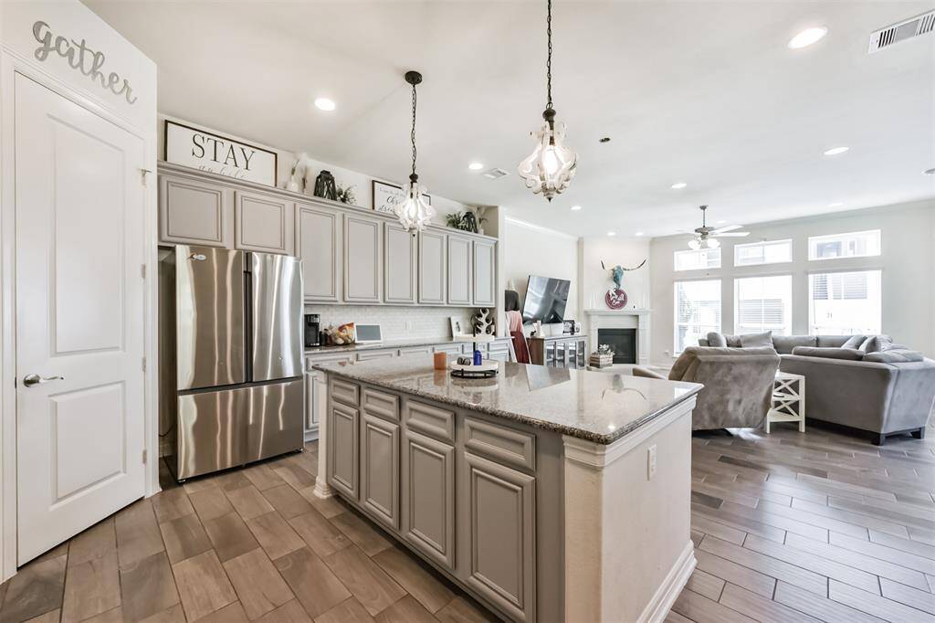 Chef's eat-in island kitchen features an abundance of cabinets, lengthy granite countertops and stainless steel appliances