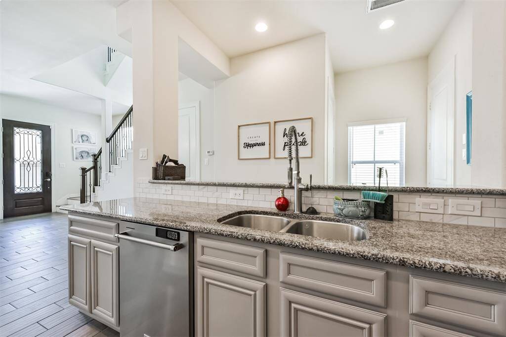 Chef's eat-in island kitchen features an abundance of cabinets, lengthy granite countertops and stainless steel appliances