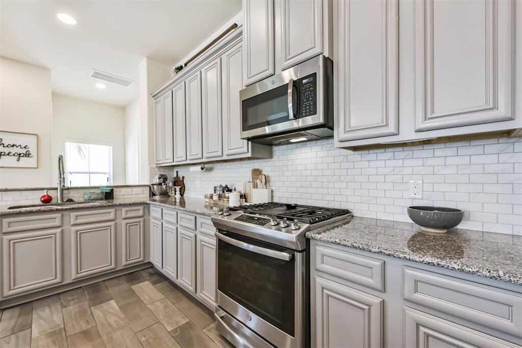 Chef's eat-in island kitchen features an abundance of cabinets, lengthy granite countertops and stainless steel appliances