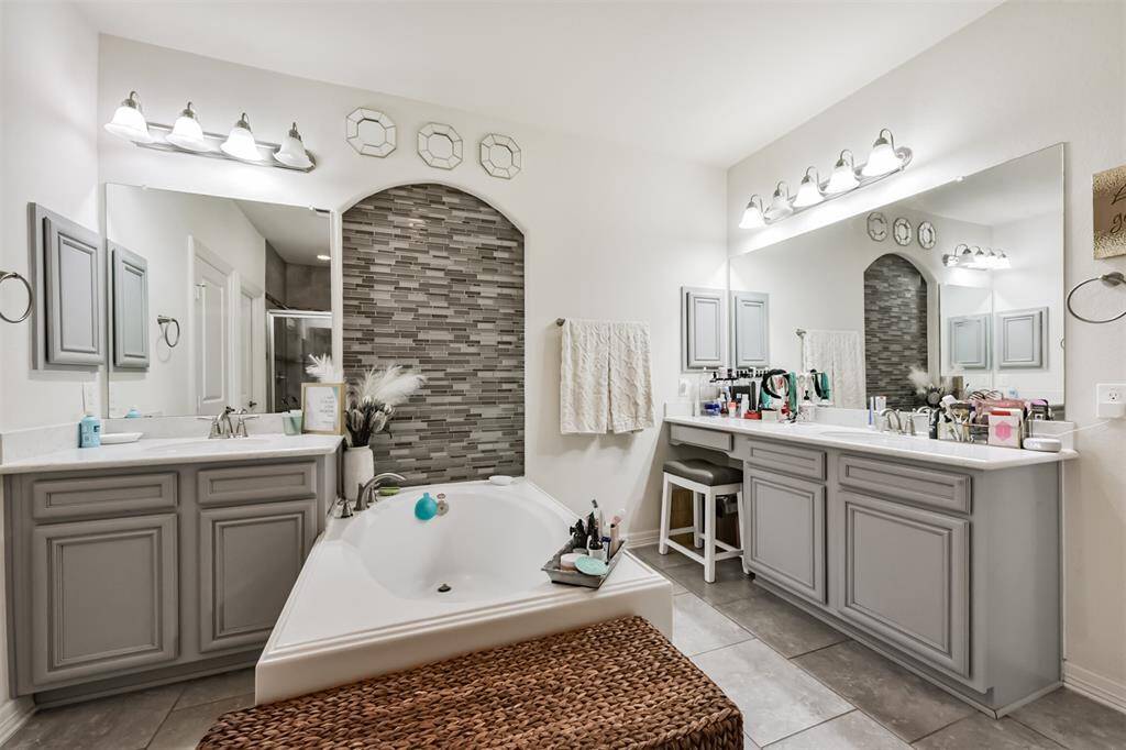 Primary en-suite bath features a walk-in shower, soaking tub, dual vanities and a walk-in closet
