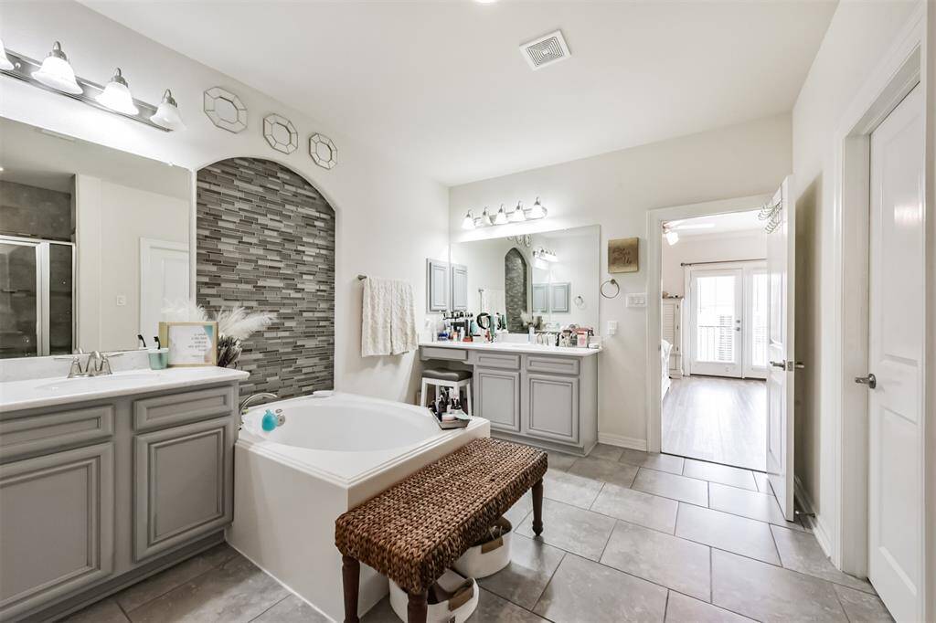 Primary en-suite bath features a walk-in shower, soaking tub, dual vanities and a walk-in closet
