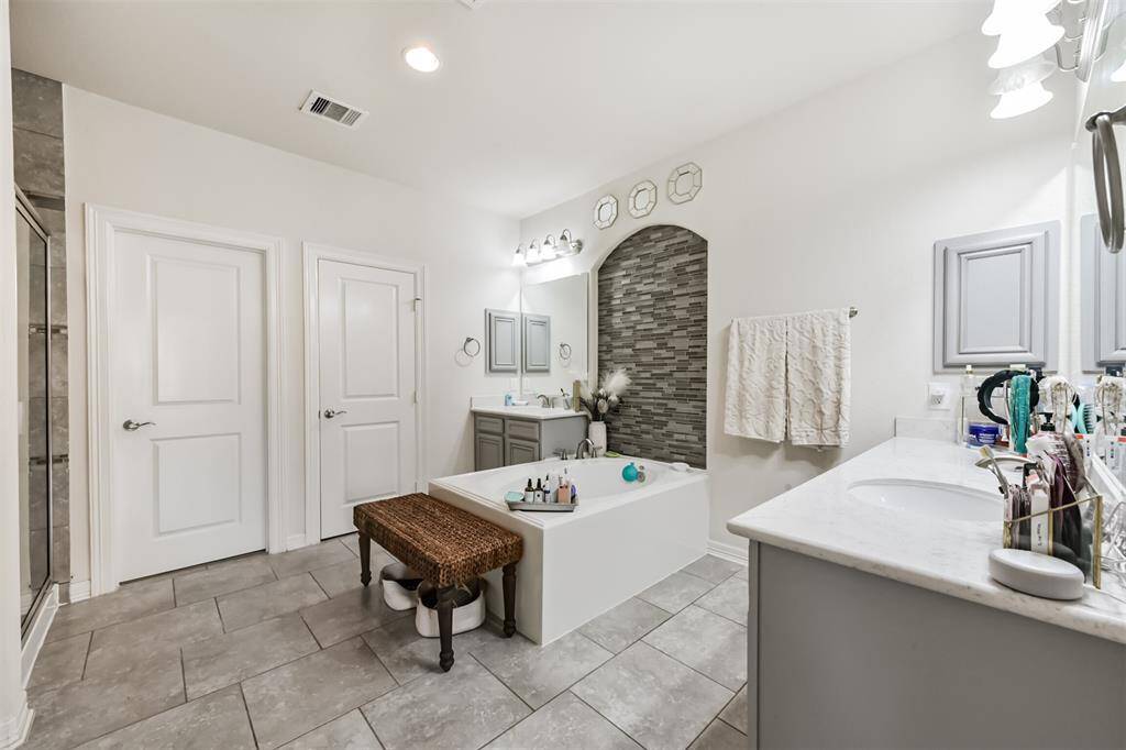Primary en-suite bath features a walk-in shower, soaking tub, dual vanities and a walk-in closet