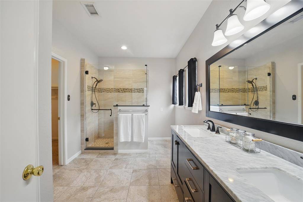 Step into the beautifully updated primary bathroom with double sinks.