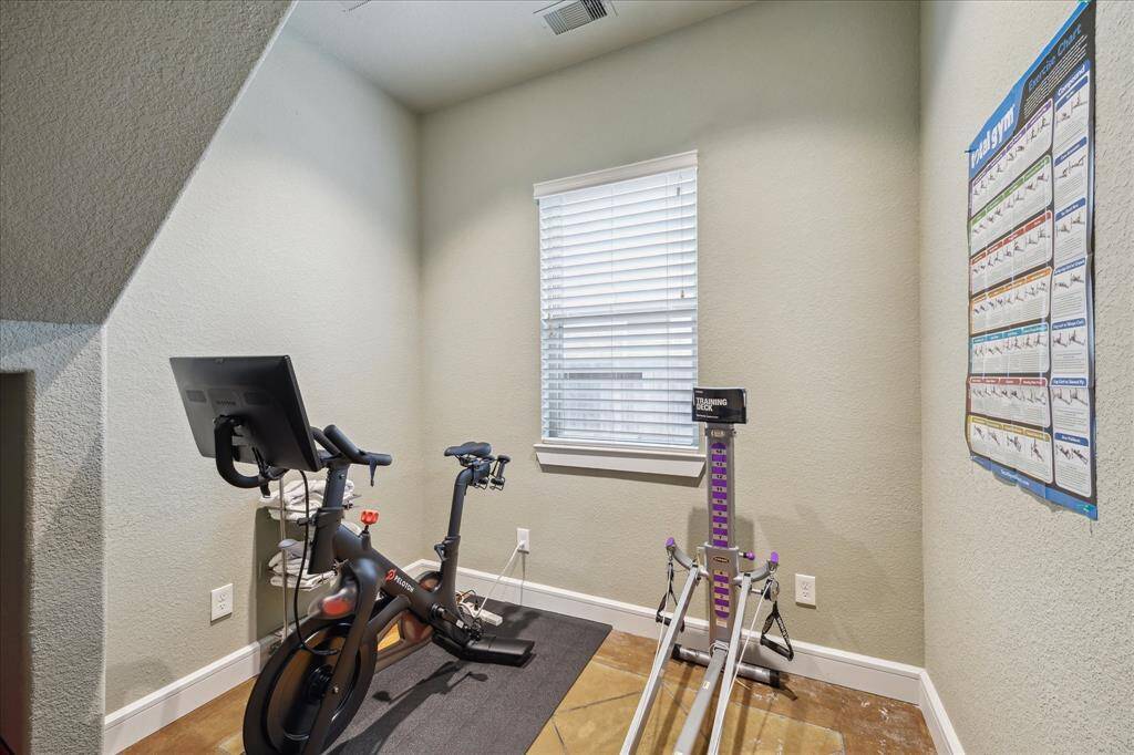 Cozy and climate-controlled exercise room off of the garage that could be returned to a 3rd car bay.