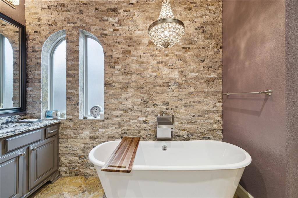 Relax in the pleasing soaking tub with crystal chandelier above.