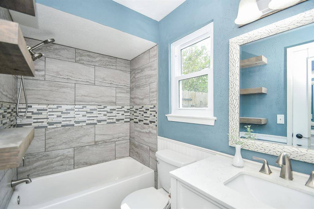 Primary en-suite bath with beautiful tile and light fixture.