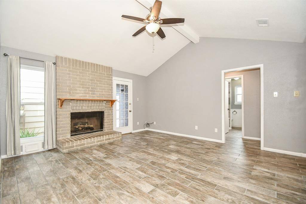 High ceilings, gas fireplace, fresh paint and wood look tiles.