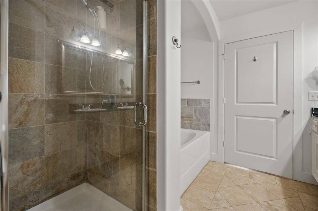 Primary bathroom has separate slate surround shower and separate tub.