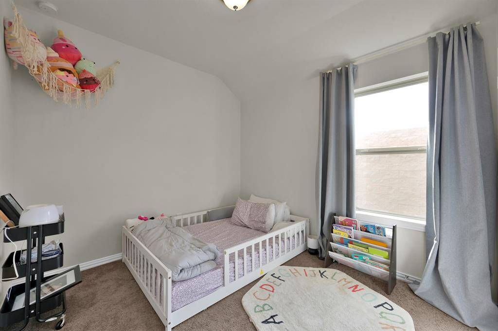 Secondary bedroom with neutral tones and bright natural lighting.