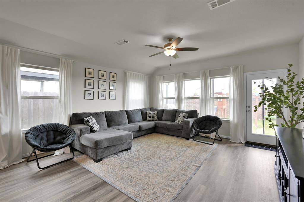 Bright and welcoming living room with upgraded flooring and abundant natural light.