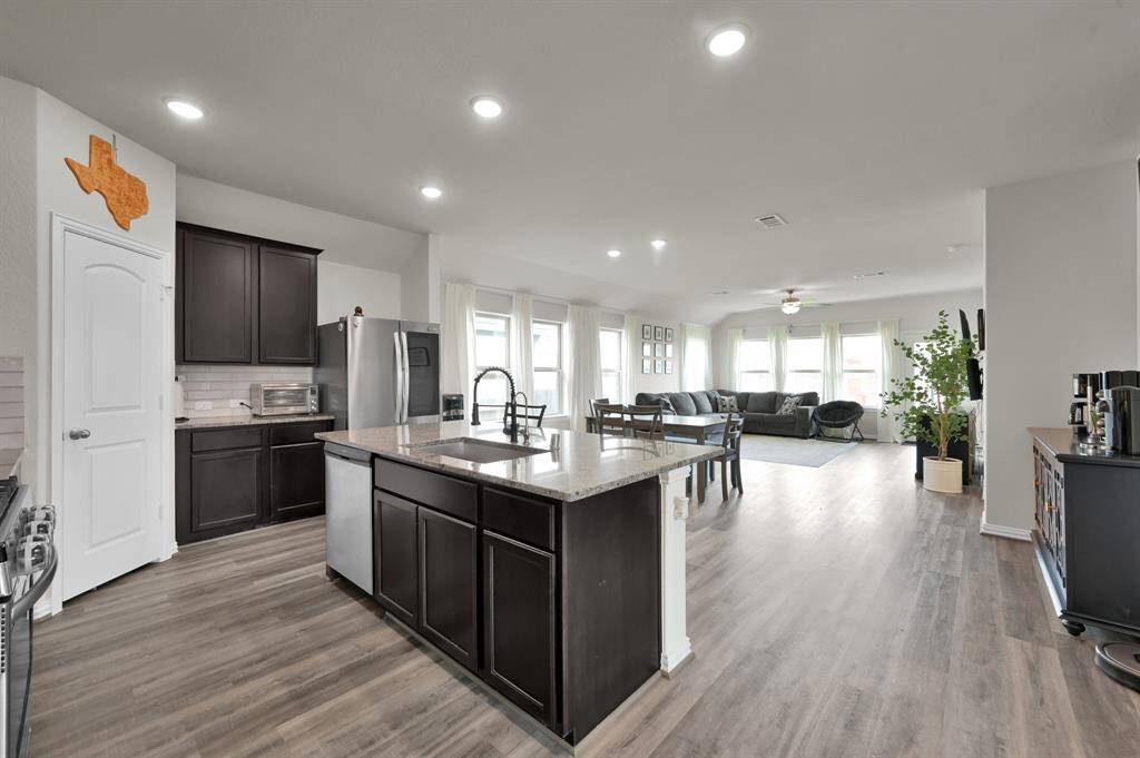 Open-concept layout that connects kitchen, dining, and living spaces with elegant lighting.