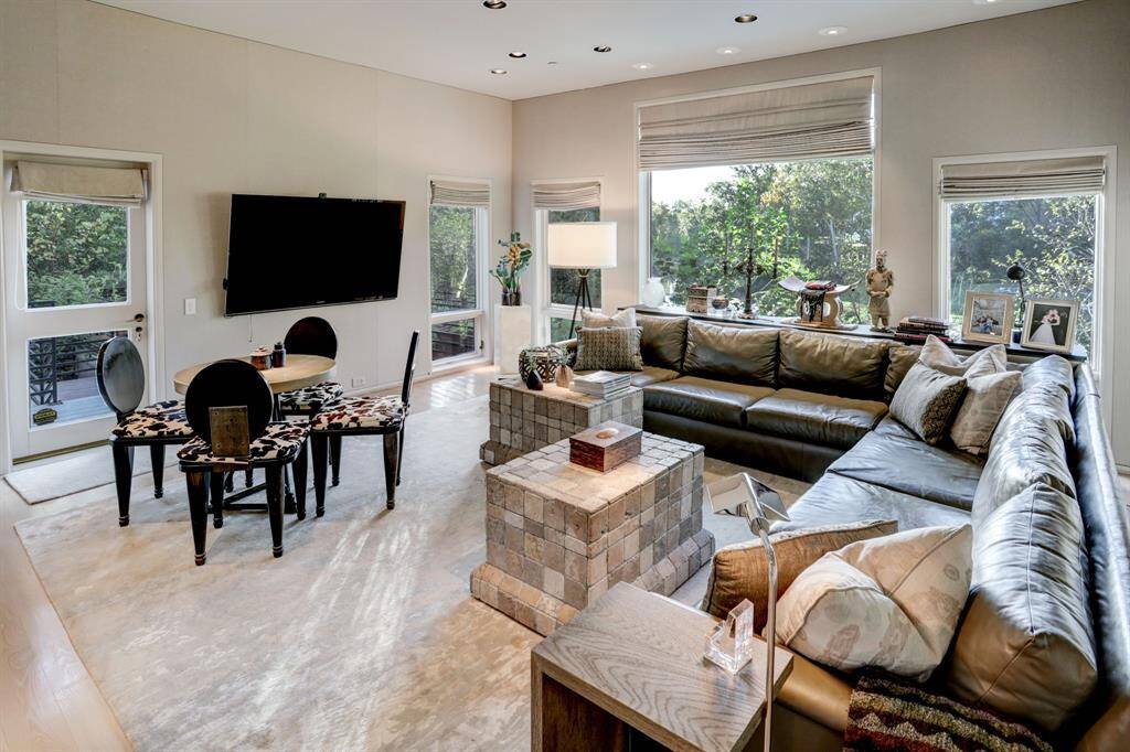 The inviting family room, seamlessly connected to the kitchen, where expansive windows frame serene wooded views.