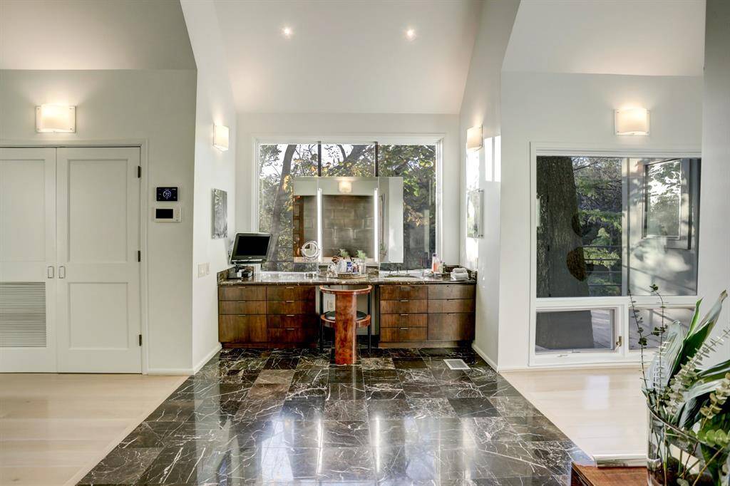 The Marble-clad bathroom offers two spacious closets, and direct access to outdoor decks.