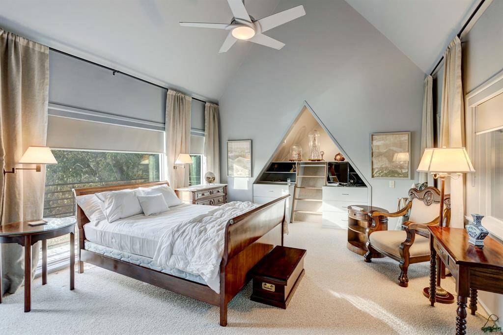 Another secondary bedroom featuring soaring vaulted ceilings and expansive windows.