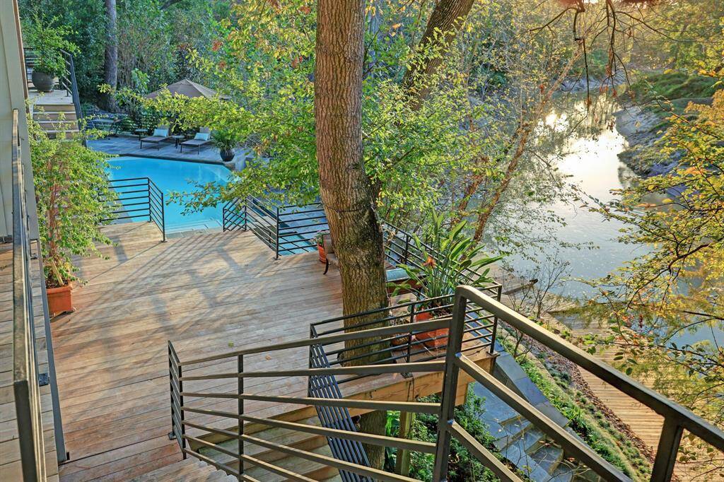 The rear grounds are a haven of tranquility, featuring wooden decks, walkways, and gravel trails.