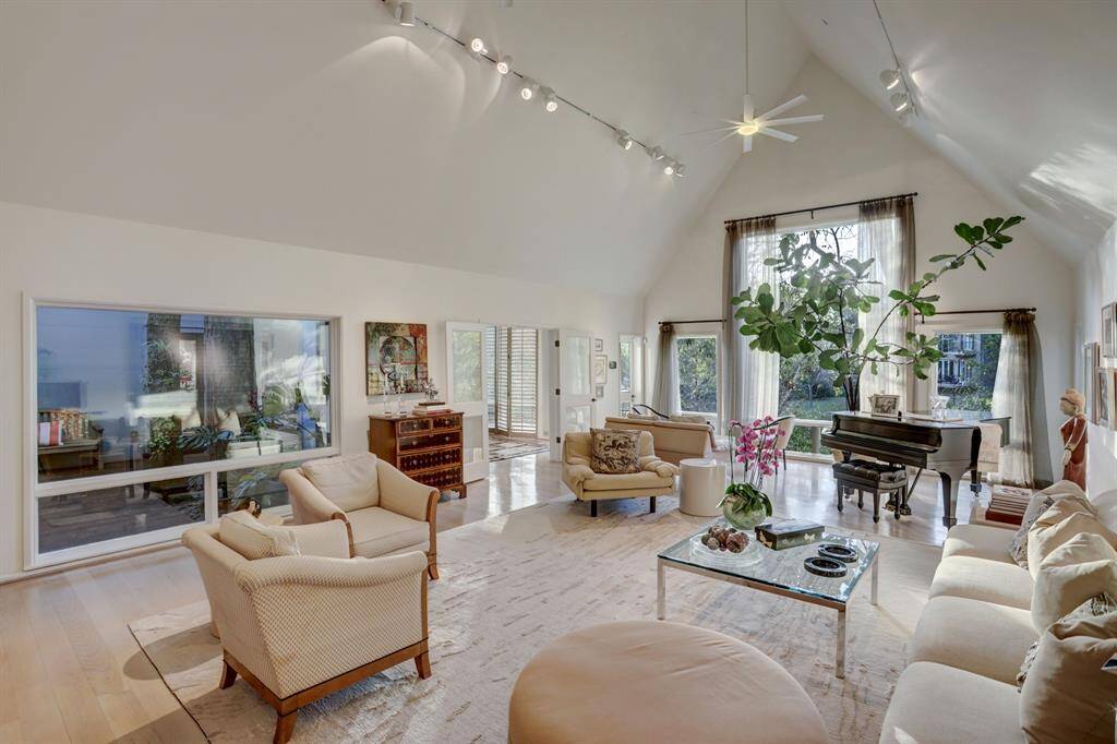 Step into this exquisite formal living room, where elegance meets tranquility. The room boasts soaring vaulted ceilings that create an airy and spacious atmosphere, complemented by a series of large windows that frame breathtaking views of the bayou.