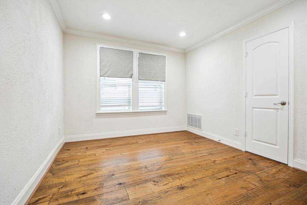 The second of two secondary bedrooms features hardwood floors, crown molding, recessed lighting, and a neutral palette—ready to be personalized.