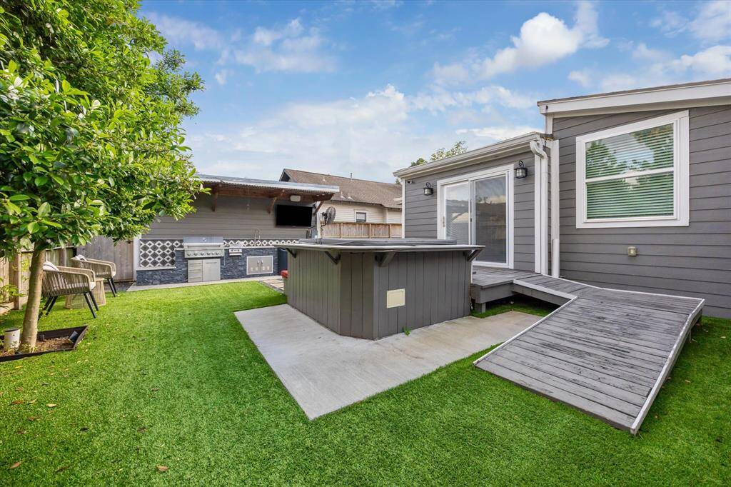 Step out from the primary suite to your private backyard oasis featuring a 2021-installed Jacuzzi hot tub, artificial turf, and a custom ramp—perfect for relaxation and accessibility.
