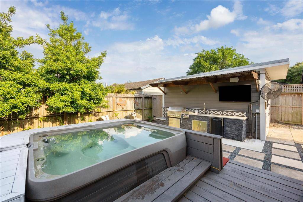 Unwind in the oversized hot tub while enjoying views of the beautifully designed outdoor kitchen and lounge area. A convenient outdoor shower and changing room tucked behind the converted garage make this backyard retreat both stylish and functional.