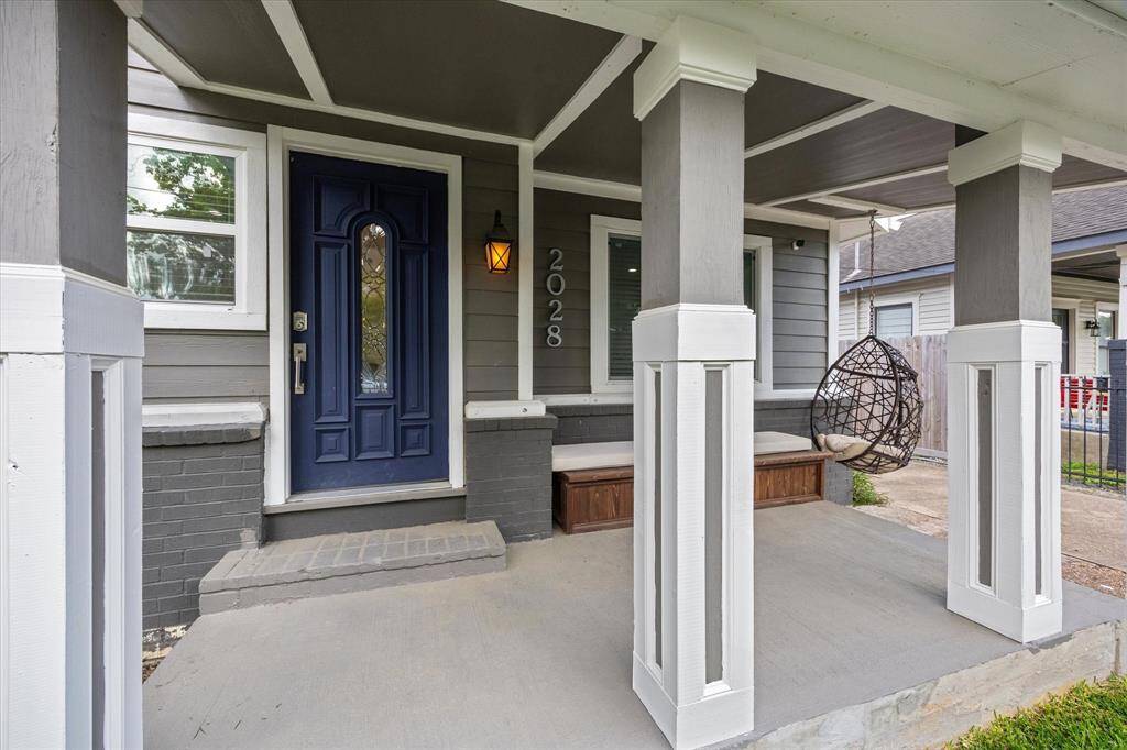 A welcoming covered front porch sets the tone at 2028 Gostick, offering built-in bench seating, a cozy swing, and plenty of space to relax or greet guests—perfect for enjoying quiet mornings or friendly chats.