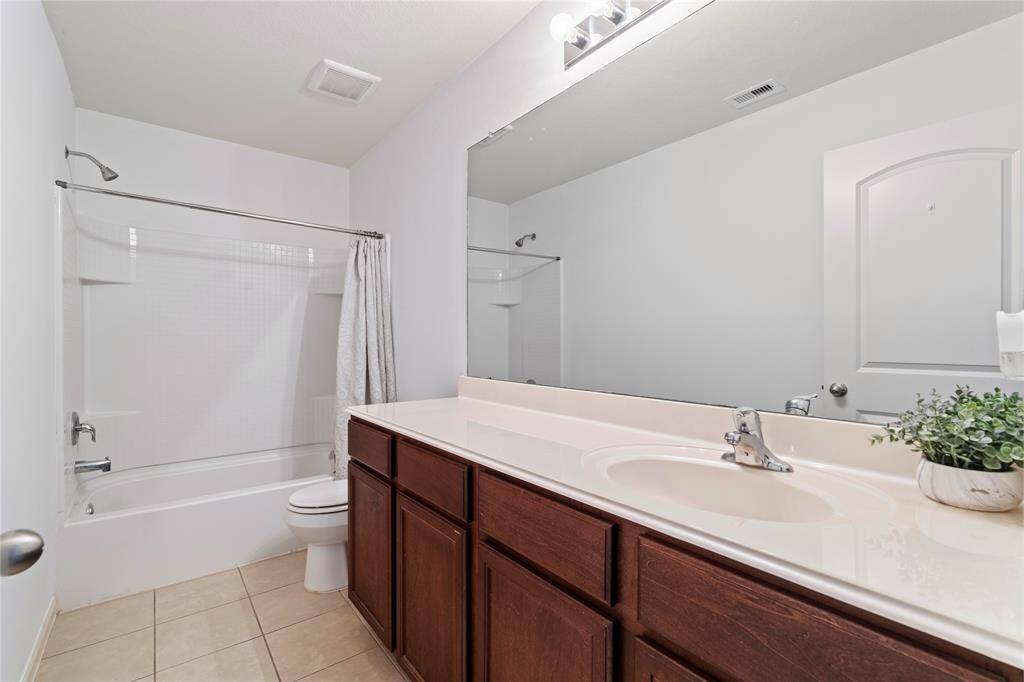 Functional secondary bathroom featuring a spacious vanity and a shower/tub combo.