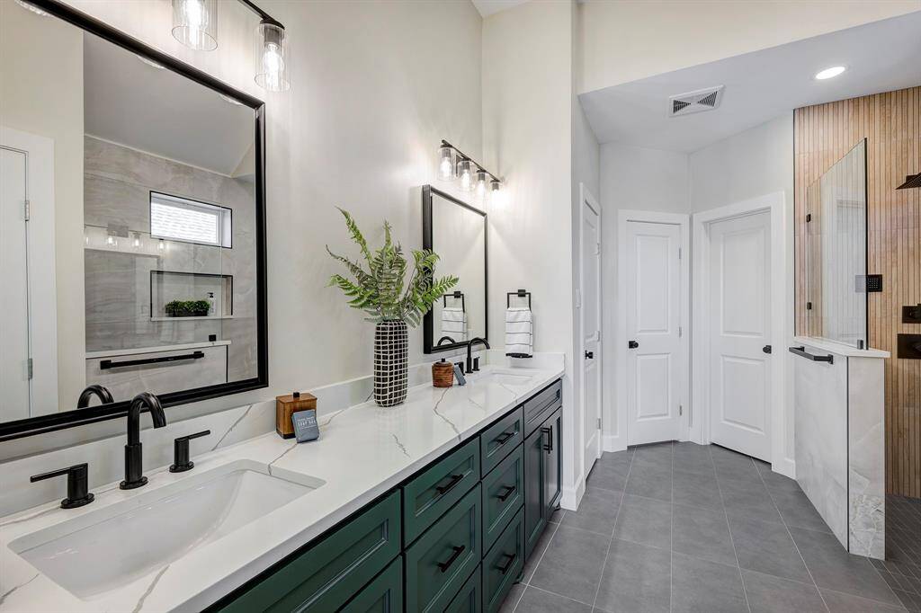 The primary bathroom has a custom dual vanity, quartz countertop, 2 walk-in closets with additional built-ins, private toilet with bidet and a massive shower.