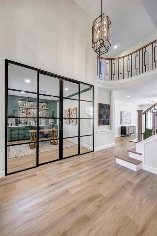 Step inside to discover expansive open-concept living spaces featuring white oak luxury vinyl plank flooring throughout the main level. As pictured, the dedicated home office is situated to the left, while the elegant dining room is to the right.