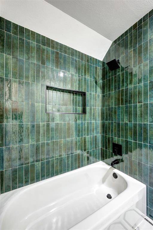 The shower tub combo has gorgeous designer tile, recessed shampoo niche and modern fixtures.
