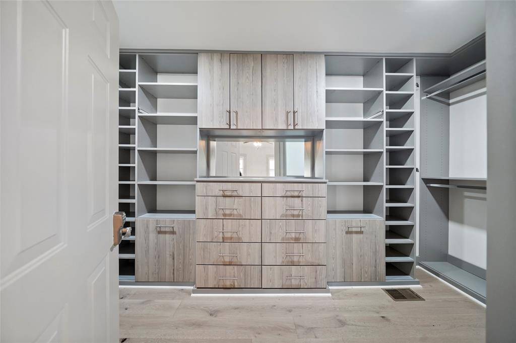 Huge primary bedrooms walk-in closet with built-in shelves and built-in mirror.