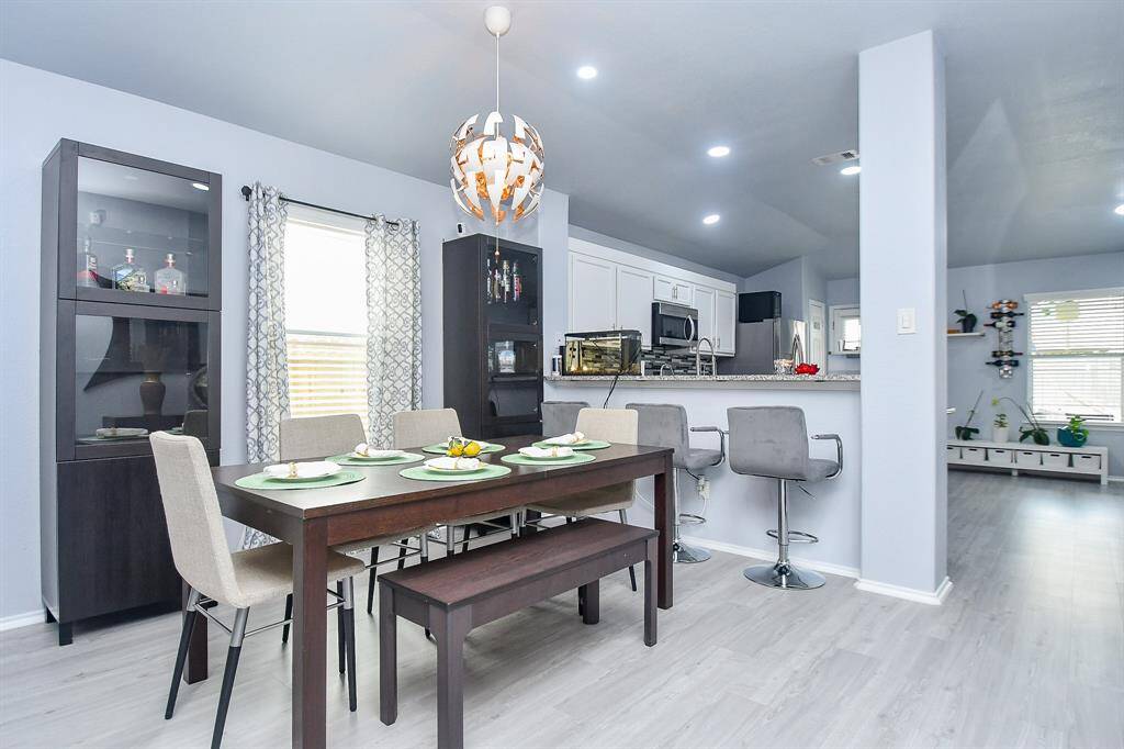 The timeless open floor plan concept embraces everything about your lifestyle choices. Here, in a formal dining setting (with extra seating, if needed, at the counter, right), eating and socializing naturally come together with shared living space, beyond.