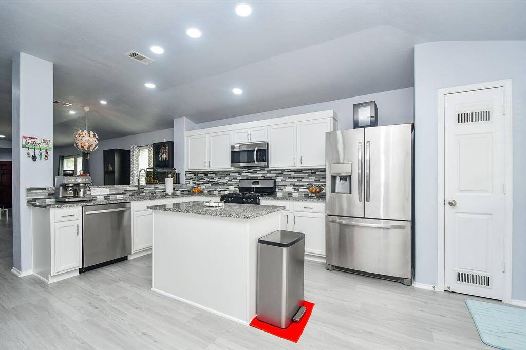 You can cook up a storm in this open kitchen, and still socialize with guests in the living area! (Stainless steel appliances add to the glow of this great space.)