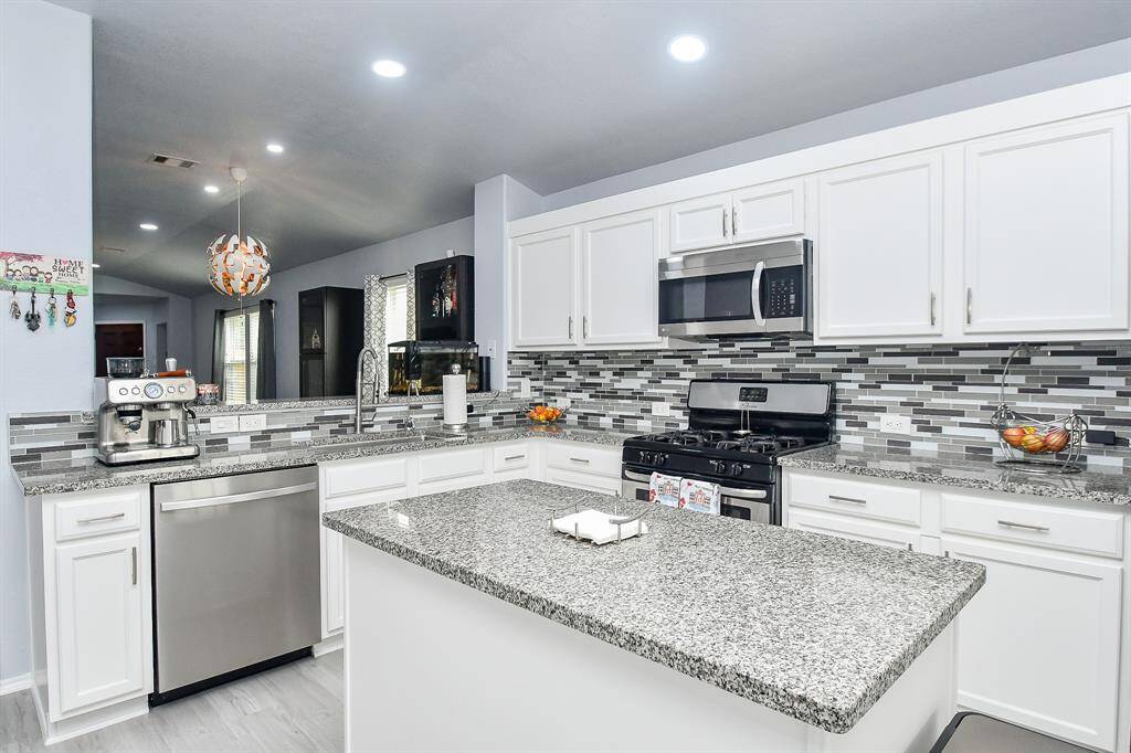 Stand at the sink to pop open a celebratory bottle of champagne, while family and friends line up with treasured champagne flutes, at the kitchen counter, left.
