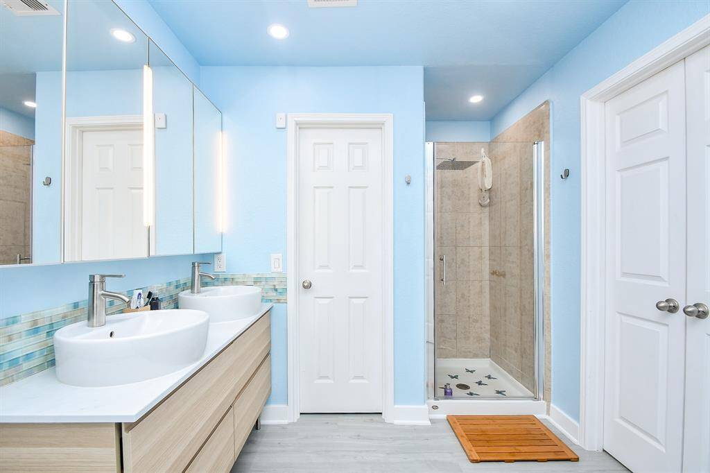 The walk-in, rimless, glass enclosed shower is nicely tucked away.