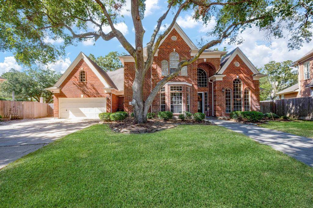 Lush, native greenery embraces this exquisite single family, 2-story, brick beauty at 23014 Laguna Point Drive, Katy, TX, in the South Lake gated community.