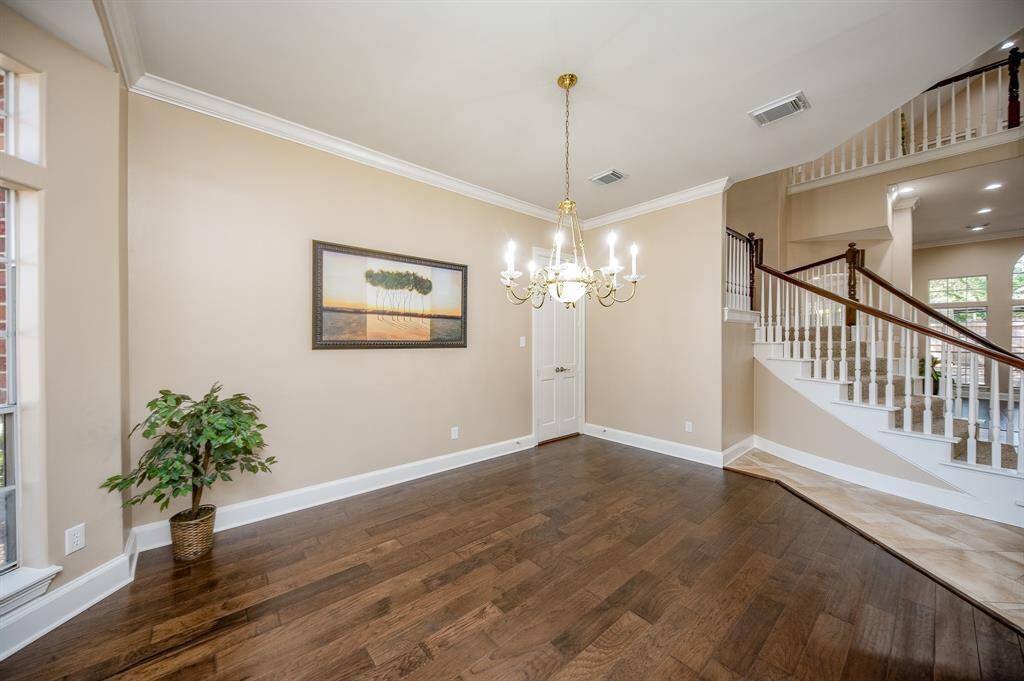 This warm interior view of the formal dining area offers just enough privacy and a pleasant visual connection to hallway and staircase.