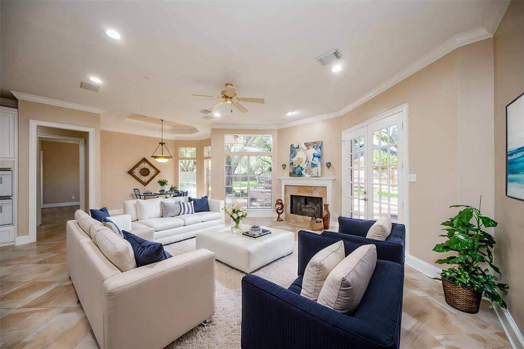 This jewel box of a living area magically invites family and friends with luscious tile flooring, high ceiling, lots of natural light and a corner fireplace, as the star of the show!