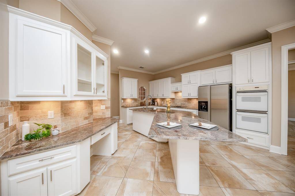 There's just something about a primarily white kitchen that warms and invites us, in any genre or style! Here, we have a streamlined version of such, with lots of cabinetry, new earth toned granite counters and room, galore!