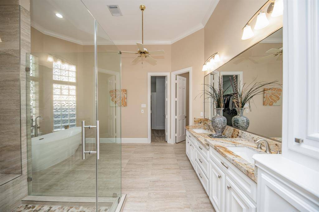 Rain, shine --- or somewhere in between --- this primary ensuite bath will transport you to luxurious personal care; with fantastic floor space, dual sinks, wall-wide mirror and delicate lighting, above; and rimless walk-in shower and free standing soaking tub, left.